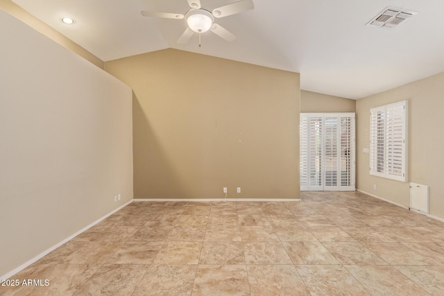 spare room featuring baseboards, a ceiling fan, vaulted ceiling, and visible vents