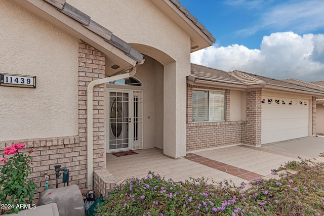 view of exterior entry with a garage