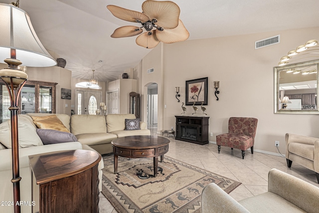 tiled living room featuring a fireplace, vaulted ceiling, and ceiling fan