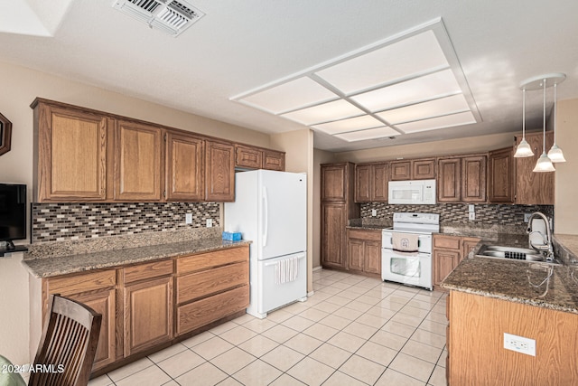 kitchen featuring sink, hanging light fixtures, backsplash, dark stone counters, and white appliances