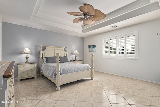 bedroom with light tile patterned floors, a tray ceiling, and ceiling fan