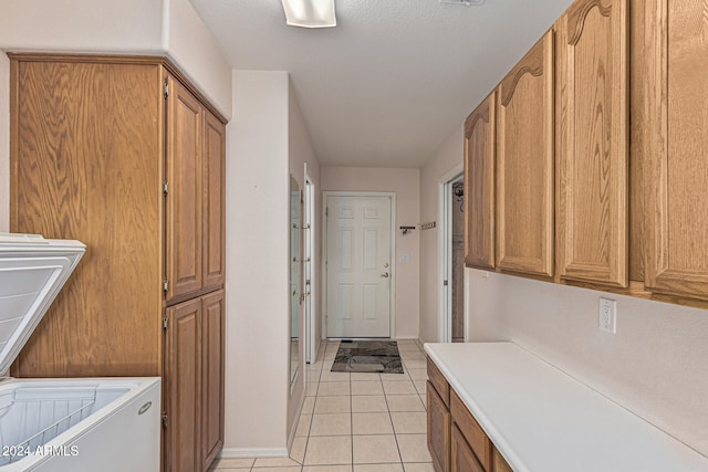 laundry room with cabinets and light tile patterned flooring