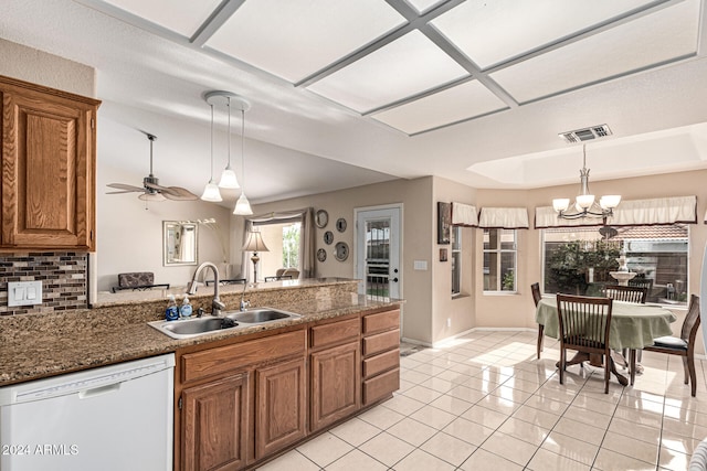 kitchen featuring dishwasher, sink, hanging light fixtures, backsplash, and ceiling fan with notable chandelier