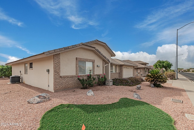 view of front of property with a garage and central air condition unit