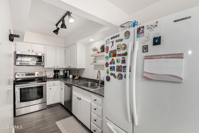 9046 N 51st Ln, Glendale, AZ 85302 - kitchen with a sink, appliances with stainless steel finishes, dark countertops, and white cabinetry