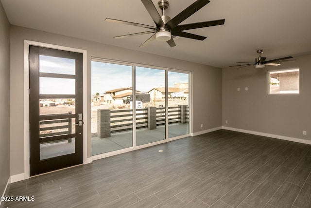 392 Schoppman Ln, Page, AZ 86040 - unfurnished room featuring baseboards, plenty of natural light, ceiling fan, and dark wood-type flooring