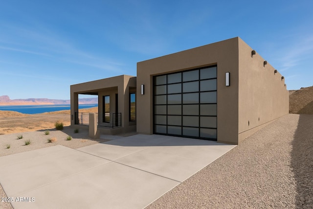 392 Schoppman Ln, Page, AZ 86040 - view of front facade featuring stucco siding, driveway, and a water and mountain view