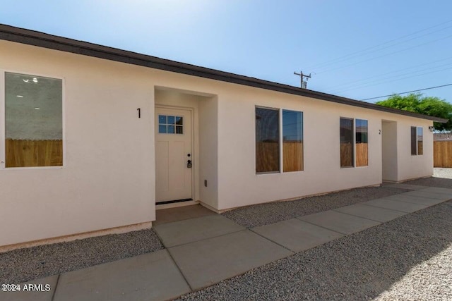 exterior space featuring fence and stucco siding