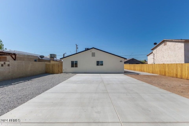 back of property with fence and a patio