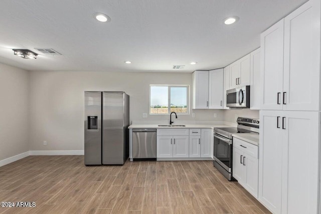 kitchen with visible vents, stainless steel appliances, light countertops, light wood-style floors, and a sink