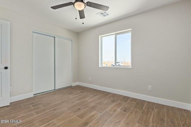 unfurnished bedroom featuring ceiling fan and a closet