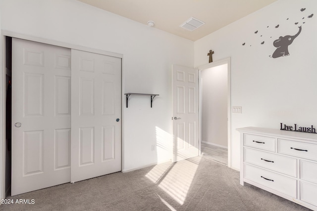 unfurnished bedroom with a closet and light colored carpet