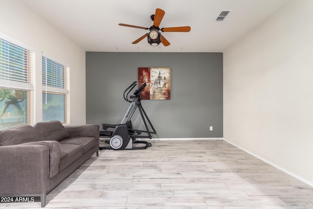 exercise room with ceiling fan and light hardwood / wood-style flooring