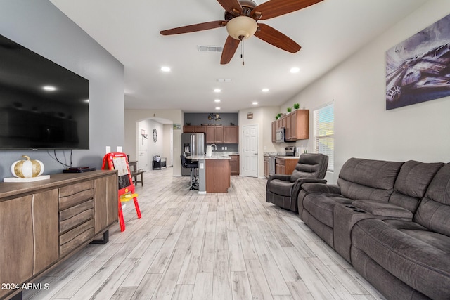 living room featuring ceiling fan and light hardwood / wood-style flooring