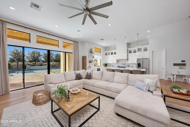 living room with ceiling fan and light hardwood / wood-style flooring