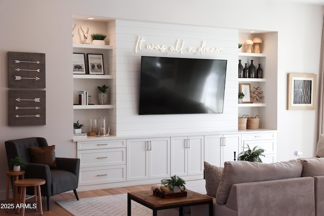 living room with built in features and light hardwood / wood-style flooring