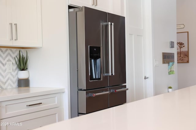 kitchen featuring tasteful backsplash, high end fridge, and white cabinets