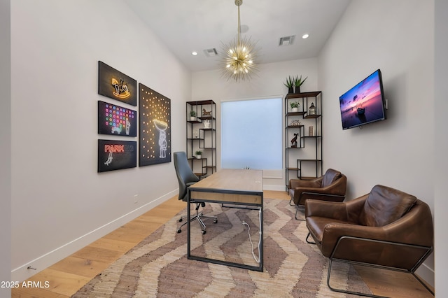 home office with wood-type flooring and a chandelier