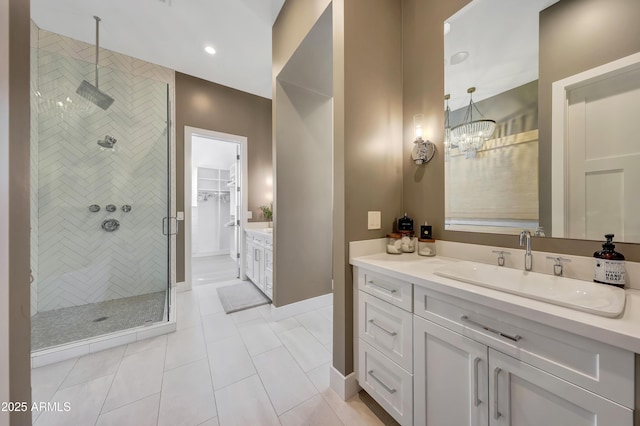 bathroom with a shower with door, vanity, tile patterned flooring, and an inviting chandelier