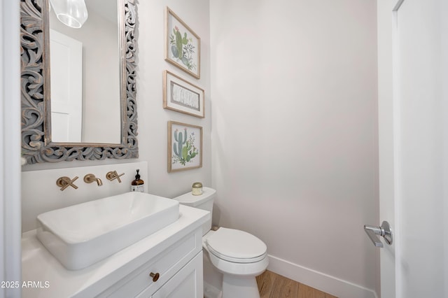 bathroom with hardwood / wood-style flooring, vanity, and toilet