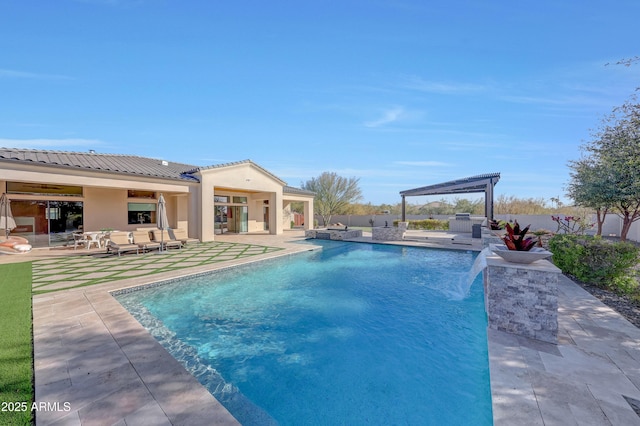 view of pool with pool water feature, area for grilling, a patio, and an outbuilding