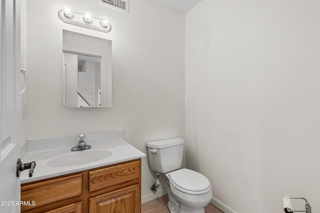 bathroom with vanity, baseboards, visible vents, tile patterned floors, and toilet