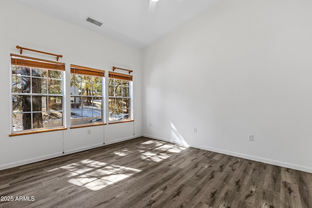 unfurnished room featuring visible vents, baseboards, and wood finished floors