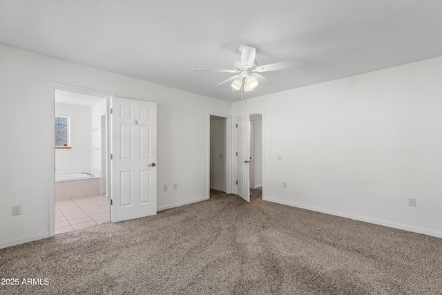 unfurnished bedroom featuring tile patterned flooring, connected bathroom, baseboards, and carpet floors