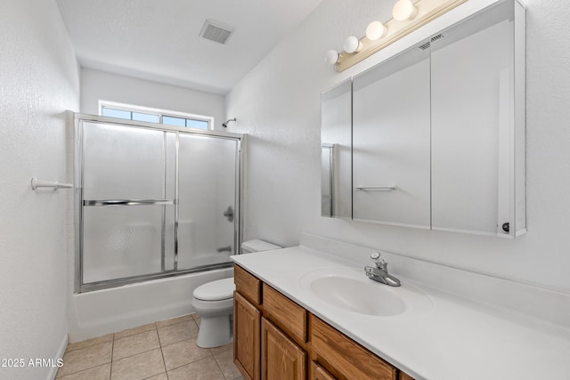 bathroom with vanity, visible vents, shower / bath combination with glass door, tile patterned floors, and toilet