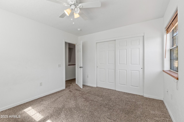 unfurnished bedroom featuring baseboards, carpet floors, a closet, and ceiling fan