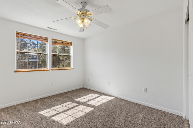 spare room with baseboards, visible vents, carpet floors, and ceiling fan