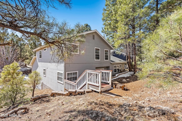 rear view of property featuring a wooden deck