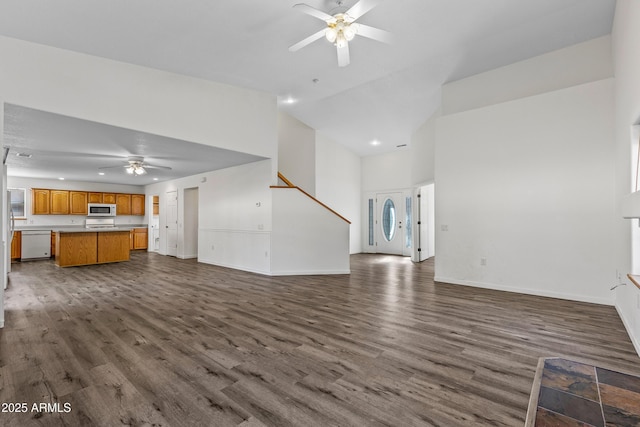 unfurnished living room featuring high vaulted ceiling, baseboards, ceiling fan, and dark wood-style flooring