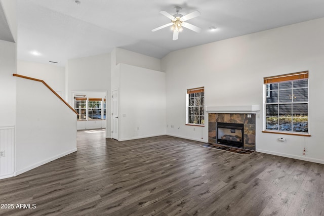 unfurnished living room featuring a tile fireplace, baseboards, a ceiling fan, and wood finished floors