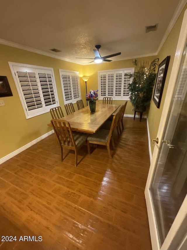 dining space featuring baseboards, ornamental molding, and wood finished floors