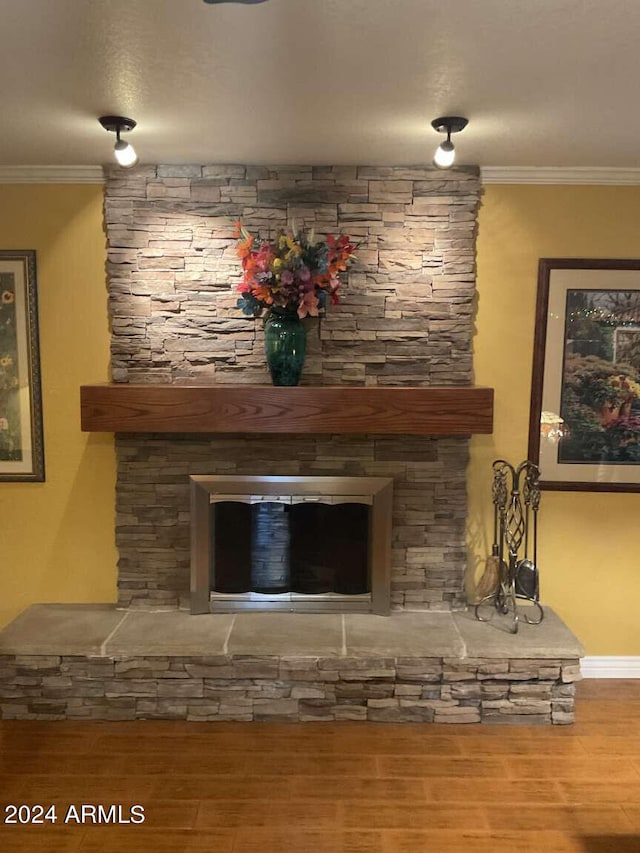 details with ornamental molding, a fireplace, and wood finished floors