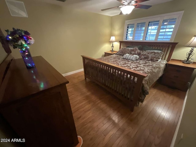 bedroom with wood finished floors, a ceiling fan, and baseboards