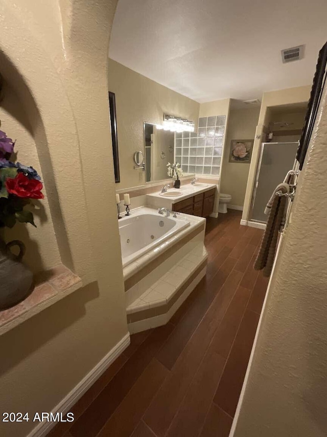 full bathroom with toilet, wood finished floors, visible vents, a shower stall, and a tub with jets