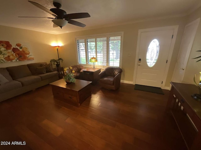 unfurnished living room with dark wood-style floors, ornamental molding, baseboards, and a ceiling fan