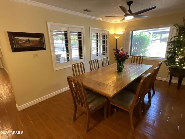 dining space featuring ornamental molding, visible vents, baseboards, and wood finished floors