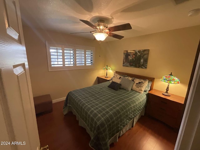 bedroom featuring ceiling fan, baseboards, and wood finished floors