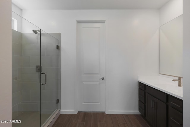 bathroom with a shower with shower door and vanity