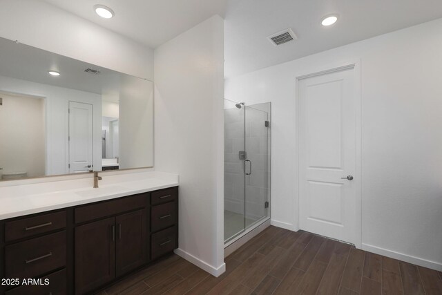 bathroom with vanity and a shower with door