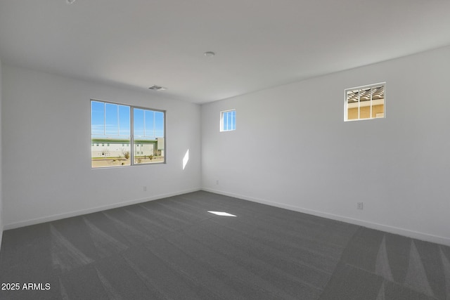 spare room with dark colored carpet