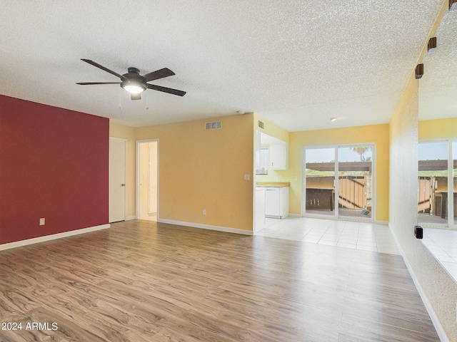 unfurnished living room with ceiling fan, light hardwood / wood-style floors, and a textured ceiling