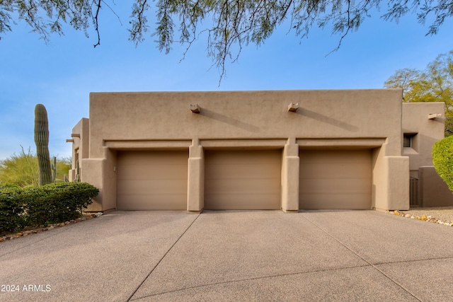 pueblo revival-style home with a garage