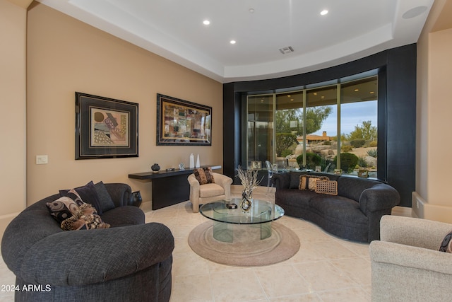 tiled living room featuring a tray ceiling