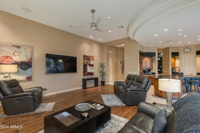 living room with hardwood / wood-style flooring, ceiling fan, and sink