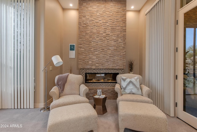 living area with light carpet and a fireplace