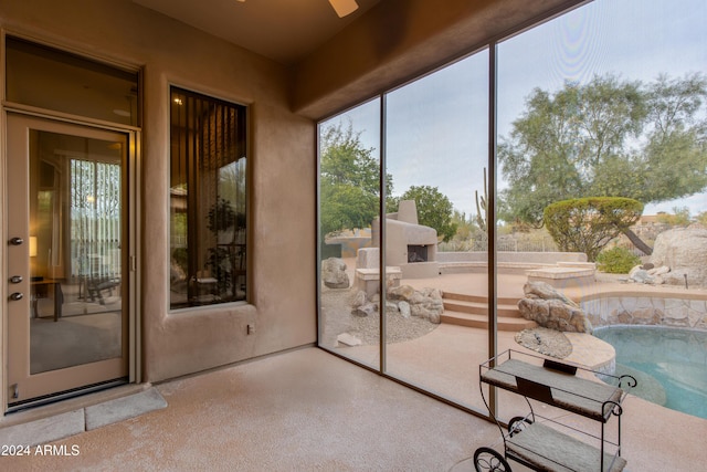 unfurnished sunroom with ceiling fan